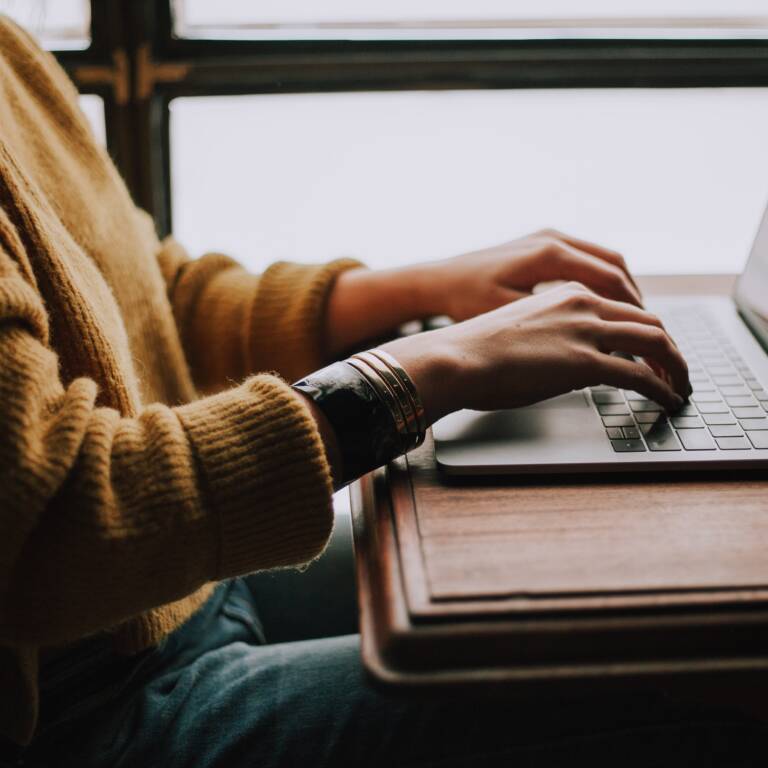 Kvinna skriver på en laptop