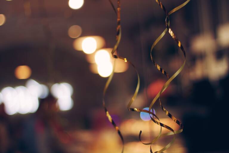 Guldfärgade erpentiner som hänger ner och skapar en festlig känsla.