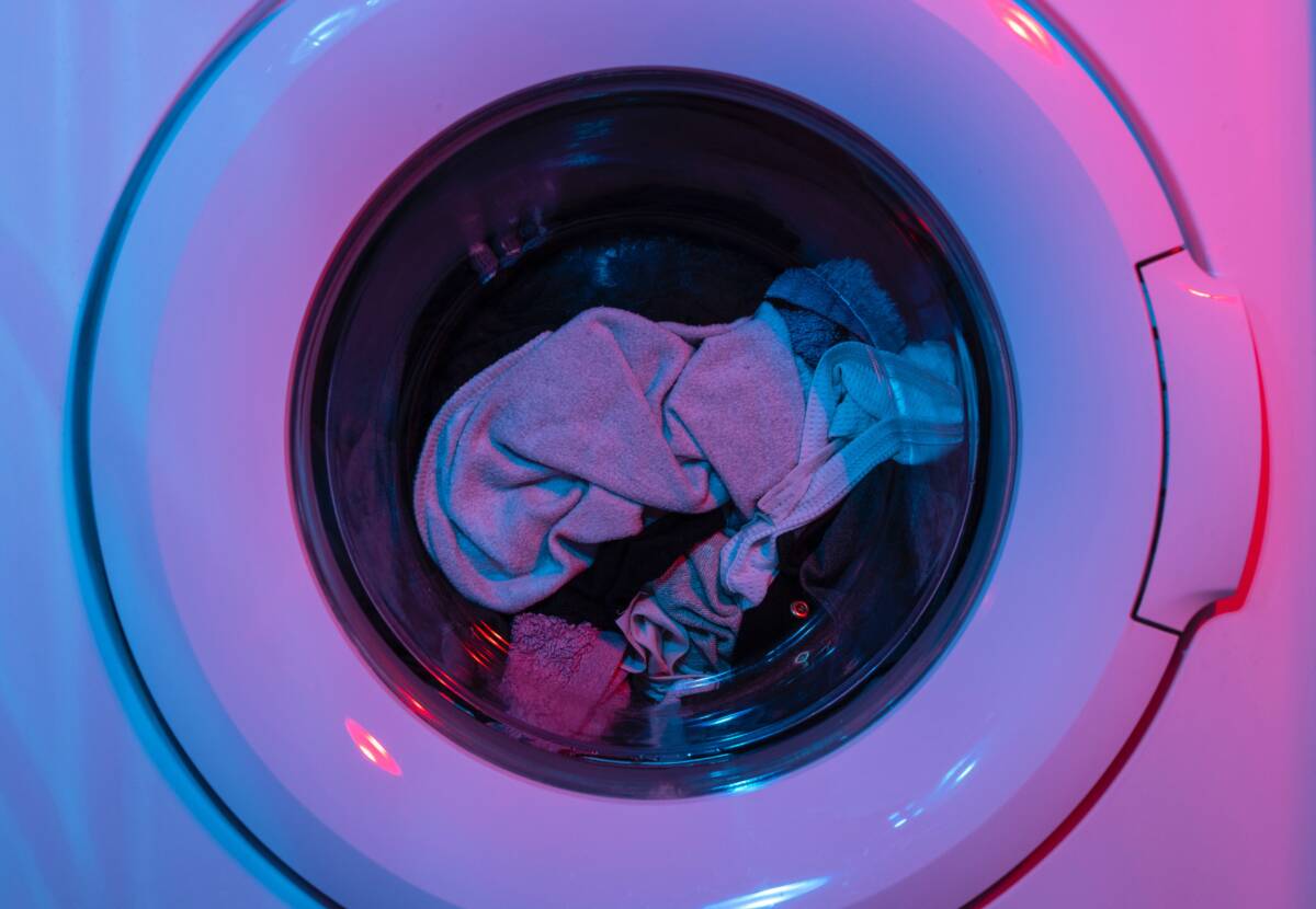 Närbild på tvätt som är lagd inuti en tvättmaskin.