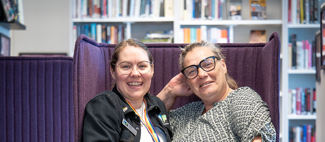 Isabella Vesala, studievägledare på Kunskapsförbundet och Åsa Jönsson, som valt att byta karriär mitt i livet. De ler. Man ser att de sitter i en soffa med en bokhylla bakom sig.